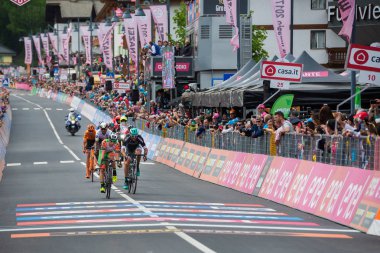 Canazei, İtalya 24 Mayıs 2017: A grubu, profesyonel bisikletçiler yorgun bitiş çizgisine tur, İtalya bitirmek 2017 yılında şehir Canazei, Kuzey İtalya ortasına sert dağına aşaması sonra geçer.