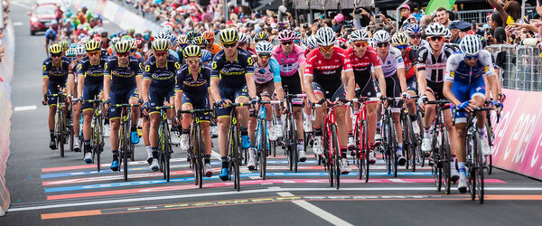 Canazei, Italy May 24, 2017: A Gorup of Professional Cyclists exhausted passes the finish line after a hard montain stage of Tour of Italy 2017 that finish in the center of city Canazei, North Italy.