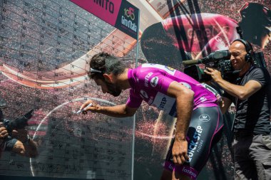 Moena, İtalya 25 Mayıs 2017: İtalya 2017, Tur Dolomites sahnede zor dağ ayrılmasından önce podyum imzalar hakkında mor Jersey profesyonel bisikletçi Fernando Gaviria