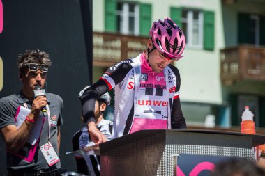 Moena, İtalya 25 Mayıs 2017: Podyum imzalar önce İtalya 2017, Tur Dolomites sahnede zor dağ hareket üzerinde pembe Jersey profesyonel bisikletçi Tom Doumulin.
