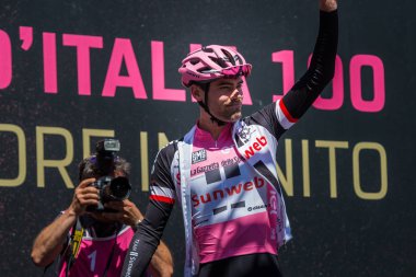 Moena, İtalya 25 Mayıs 2017: Podyum imzalar önce İtalya 2017, Tur Dolomites sahnede zor dağ hareket üzerinde pembe Jersey profesyonel bisikletçi Tom Doumulin.