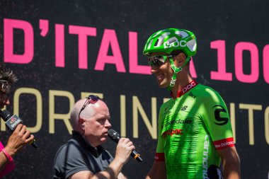 Moena, İtalya 25 Mayıs 2017: Profesyonel bisikletçi önce hareket için Dolomites İtalya tur baskı sayısı 100 sert dağ sahnede podyum imzalar hakkında.