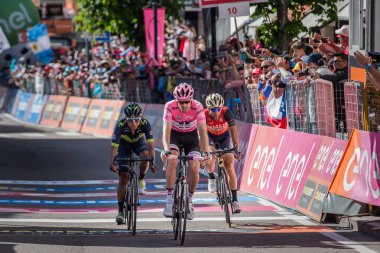 Ortisei, İtalya 25 Mayıs 2017: Profesyonel bisikletçiler Vincenzo Nibali, Tom Doumulin, Nairo Quintana yorgun bitiş çizgisine İtalya tur 2017 sert dağına aşamadan sonra geçer.