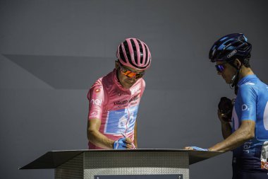 Valdaora, İtalya 30 Mayıs 2019: Richard Carapaz, pembe formalı, Giro D 'Italia 2019 dağının sert bir sahnesinde podyumda imza veriyor..