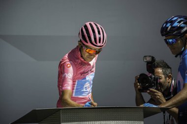 Valdaora, İtalya 30 Mayıs 2019: Richard Carapaz, pembe formalı, Giro D 'Italia 2019 dağının sert bir sahnesinde podyumda imza veriyor..
