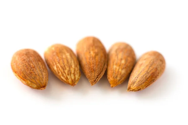 Fila, línea de almendras jóvenes peladas sobre un fondo blanco, aislado, antioxidante de frutos secos — Foto de Stock