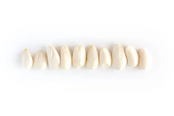 Baris, baris almond muda dikupas pada latar belakang putih, mengisolasi, kacang antioksidan — Stok Foto