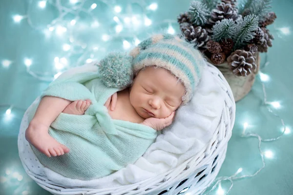 Tematem Bożego Narodzenia, dziecko w turkusowych strojach świątecznych, dziecko obok choinki i świateł — Zdjęcie stockowe