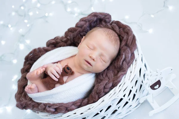 Kerstthema, slapende pasgeboren baby met teddybeer, nieuwjaarsavond concept, verlichting — Stockfoto