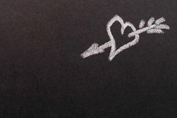 hand drawn heart with arrow on black chalk board. copy space. valentines day, all lovers concept