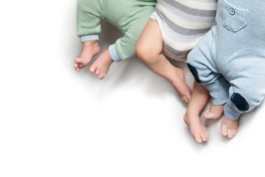 Üç çift yeni doğmuş bebek üçüzün bacağı. İkiz kardeşler. İzole et. Boşluğu kopyala 