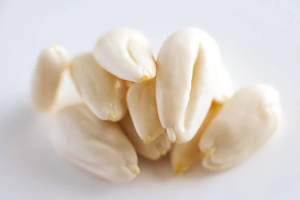 Linha, linha de amêndoas jovens descascadas em um fundo branco, isolado, antioxidante porca — Fotografia de Stock