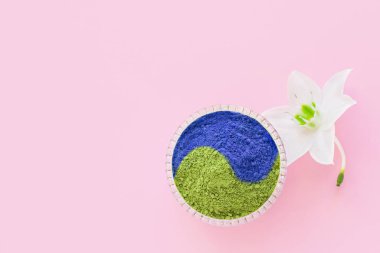 Japon çayı yapmak için pembe arka planda kibrit mavisi ve yeşil toz. Yin yang: sonsuzluk: uyum