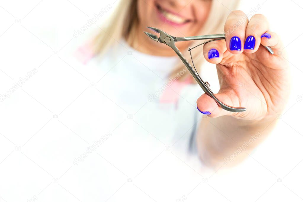 hands in colored blue medical gloves hold a manicure and pedicure tool. brush for nails. copy space. Beauty Industry Concept.