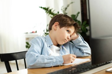 Koronovirüsteki karantina sırasında izolasyon sırasında uzaktan öğrenme. Oğlan ve dizüstü bilgisayar evde. Yaşam biçimi.