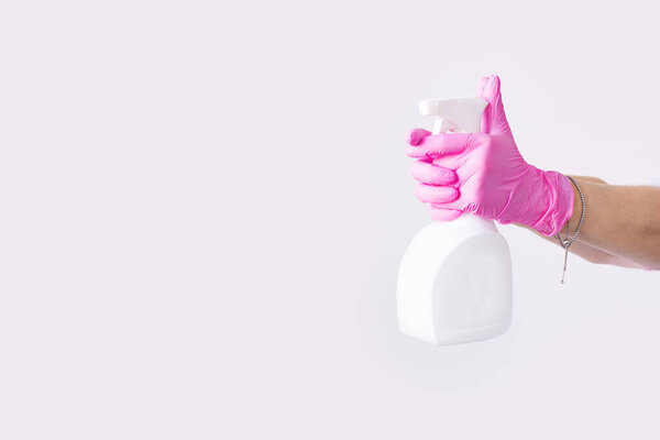 Hand in latex pink medical protection gloves white antibacterial sanitizer. Coronavirus optimistic hygiene concept. Copy space.