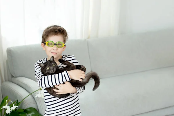 一名戴泳镜的男孩抱着一只黑猫 并梦想在2020年夏天的检疫过程中游泳 原因是考罗那未斯 年轻的冠军呆在家里 复制空间 — 图库照片