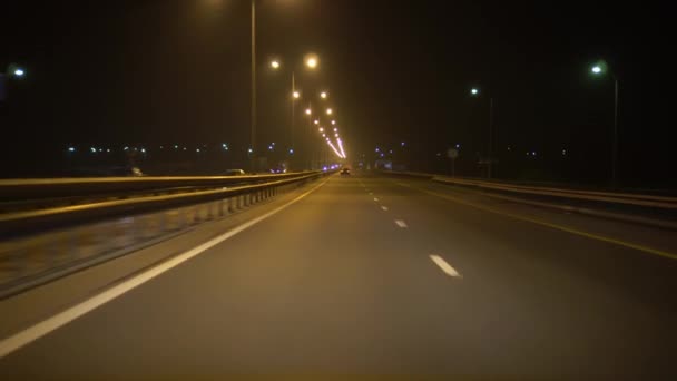 Οδηγώντας ένα αυτοκίνητο σε μια νυχτερινή λεωφόρο, από την άποψη της άποψης. Φώτα δρόμου φωτίζουν την τροχιά — Αρχείο Βίντεο