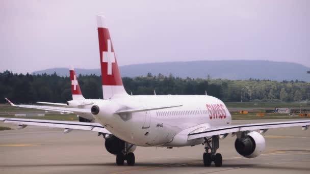 O avião começa a mover-se na pista. Deixando um rasto de escape para trás. Fechar — Vídeo de Stock