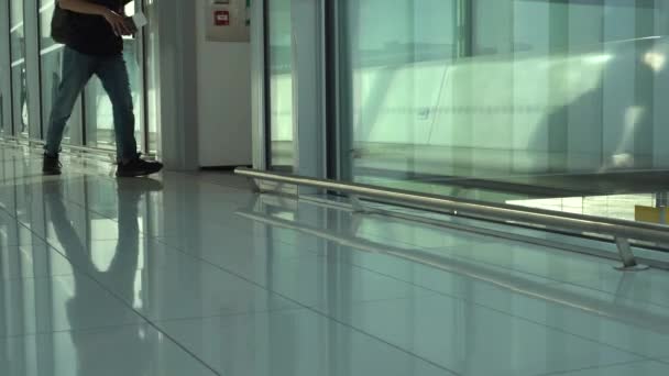 Passage de l'aéroport à la porte d'embarquement. Les gens avec des bagages montent dans l'avion. 4K — Video