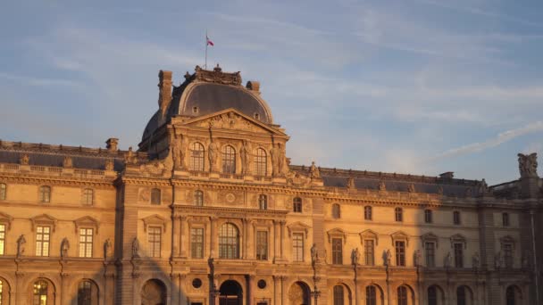 Louvre Múzeum, 1793-ban épült. A francia zászló integet a tetőn. Napnyugta. 4k — Stock videók