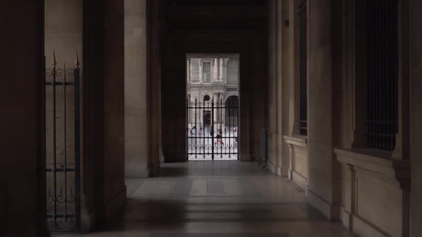 Vista através da cerca para a Praça do Louvre, onde os turistas caminham. passagem arqueada — Vídeo de Stock