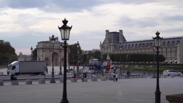 A tér a Louvre Palota előtt. A sétáló turisták szelfiket csinálnak. Autó forgalom — Stock videók