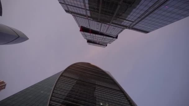 Facades of modern skyscrapers of an unusual shape. Bottom view, with rotation — Stock Video