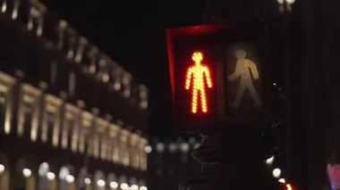 Traffic light for pedestrians at night. Looped video. Facade in the background. 