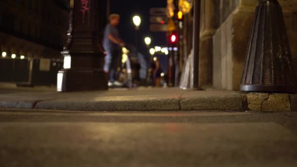 Rue Paris la nuit. Tir à partir du niveau d'asphalte. Voitures passées, gros plan 