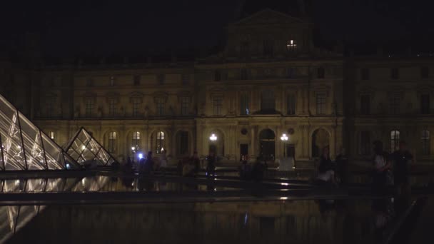 Louvre Múzeum. Homlokzat szobrokkal és oszlopokkal. Szökőkutak. Üvegpiramis. 4k — Stock videók