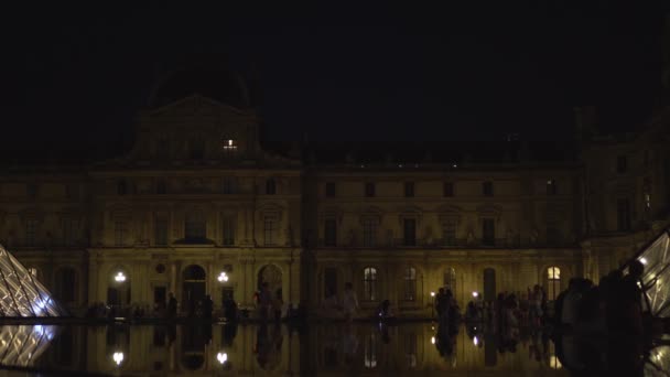 Louvre Múzeum. Homlokzat szobrokkal és oszlopokkal. Szökőkutak. Üvegpiramis. 4k — Stock videók