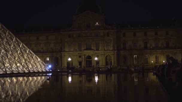 Louvre Müzesi. Heykeller ve sütunlarla dolu bir cephe. Çeşmeler. Cam piramit. 4k — Stok video
