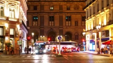 Paris caddesi. Yoğun trafik. Çok sayıda insan karşıdan karşıya geçiyor. Gece vakti.