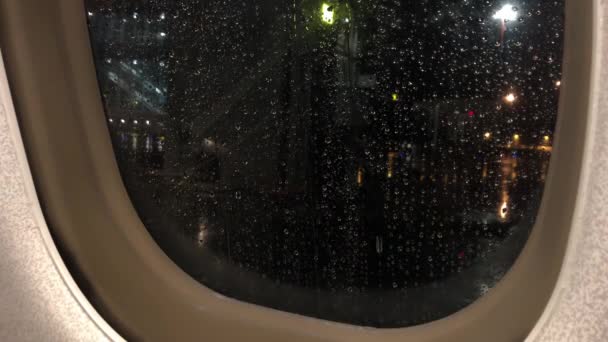 Gotas de chuva fluem pelo vidro de uma janela de avião. Vista do avião. 4K — Vídeo de Stock