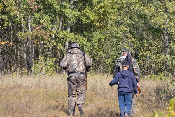 武器と子供を持つハンターは狩りに行く — ストック写真