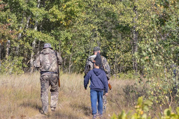 Hunters with weapons and children go hunting — Stock Photo, Image