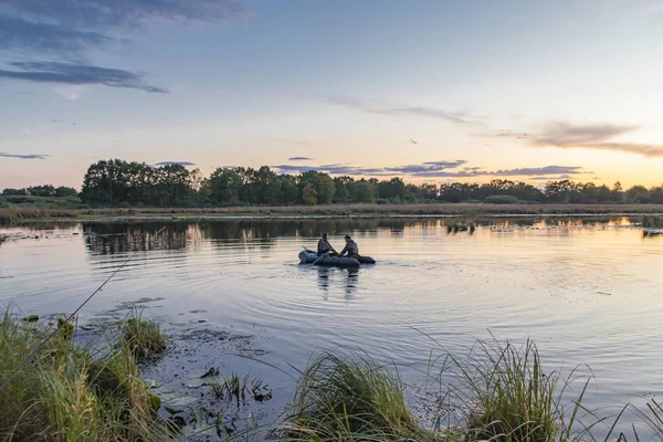 Jägare i en båt simmar i en damm på jakt efter vilda ankor — Stockfoto