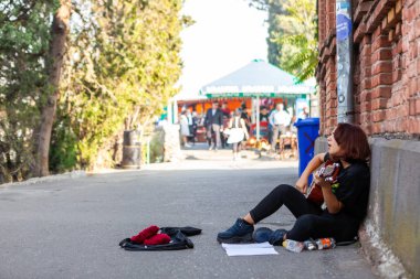 Sokakta gitar çalan genç kız.