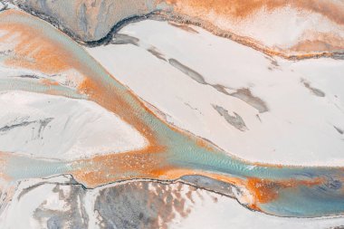 Kışın kurumuş Zhinvali su deposunun dibindeki minik turkuaz ve turkuaz akarsulardan oluşan sürrealist desenlerin havadan görünüşü