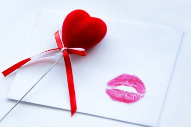 Bir kırmızı Sevgililer günü kalp ve kırmızı ruj boş beyaz kağıt arka plan öp