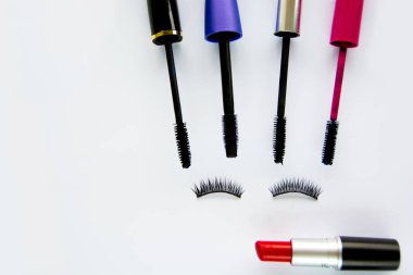 Kırmızı ruj, sahte kirpik ve beyaz arka plan üzerinde maskara