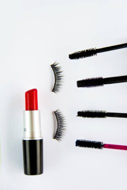 Kırmızı ruj, sahte kirpik ve beyaz arka plan üzerinde maskara