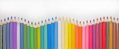 Sıraya dizilmiş çok renkli güzel kalemler, bulanık arkaplan.