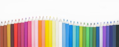 Sıraya dizilmiş çok renkli güzel kalemler, bulanık arkaplan.