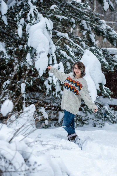 Uma menina sorridente de aparência caucasiana em uma camisola e jeans em — Fotografia de Stock