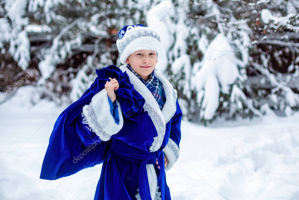 A boy in a suit of Father Frost with a bag of gifts. Cristmas presents. Winter, russian Christmas character Father Frost. Winter day.