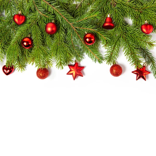 흰 바탕에는 가문비나무 가지들이 있다. 빨간 크리스마스 장난감들, 공들. 새해 카드를 위한 창의적 인 틀입니다. 크리스마스 장식. — 스톡 사진
