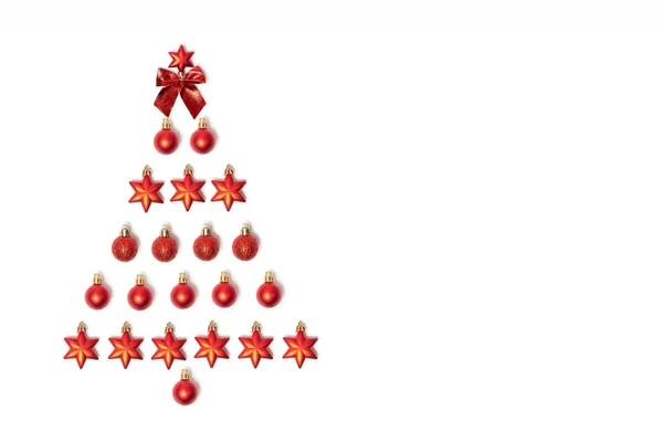 Creatieve kerstboom gemaakt van rood kerstspeelgoed. Plat gelegd. Ontwerpelementen. Plat gelegd. Nieuwjaarskaart. — Stockfoto
