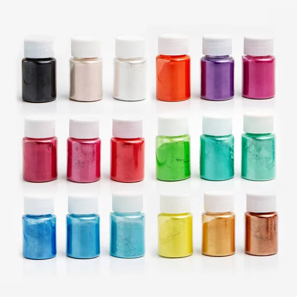 Multi-colored dyes for slimes in transparent jars on a white background. Set of 18 colors. Sparkles for slime. Holiday concept. Products for children creativity.  Children goods — 스톡 사진